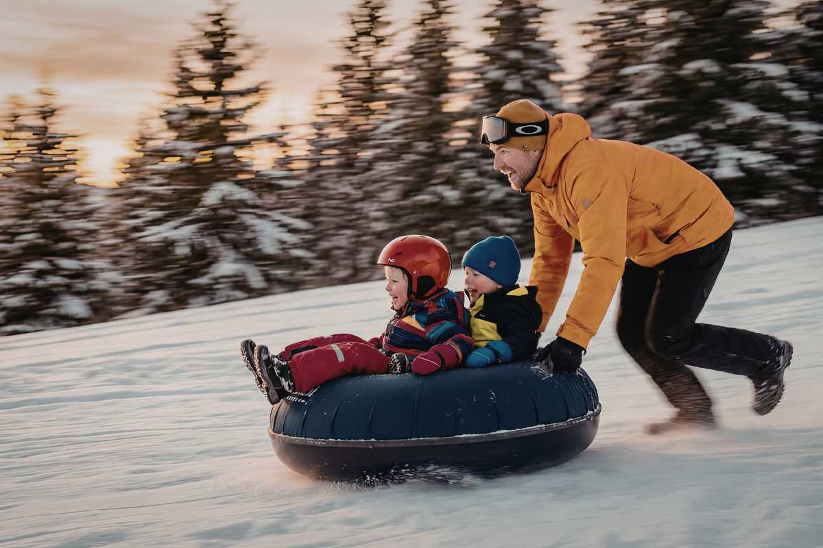 Panorama di Canazei con famiglie che giocano sulla neve
