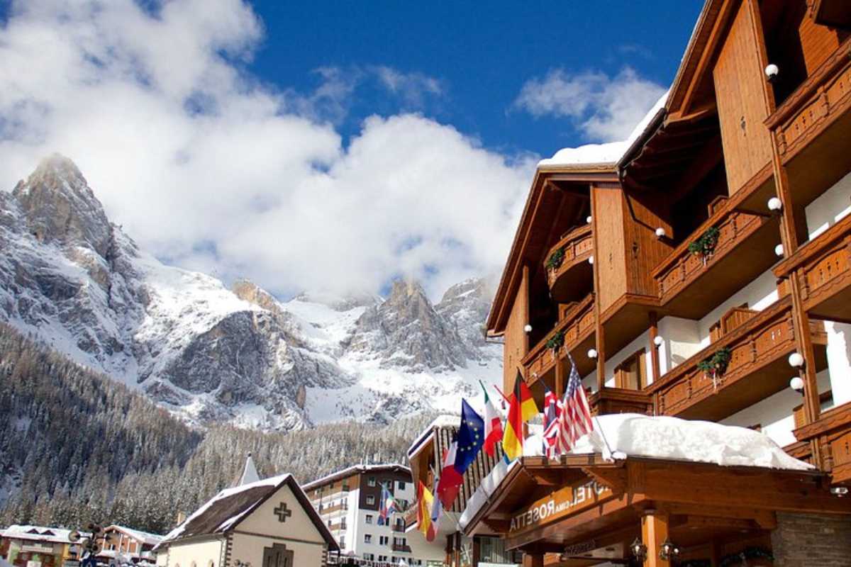 Vista panoramica delle Pale di San Martino con bambini che giocano nella neve