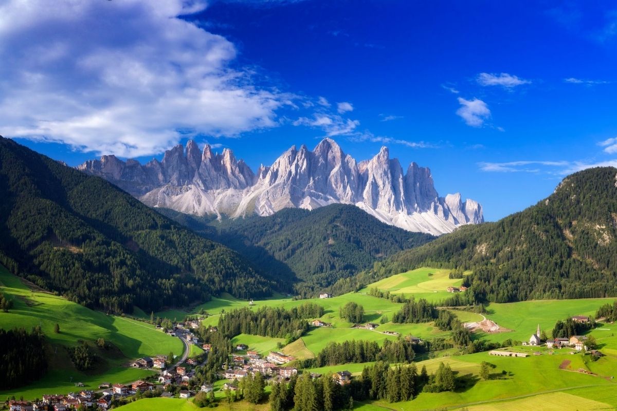 Panorama delle Dolomiti con Canazei in primo piano, evidenziando le montagne e il paesaggio naturale